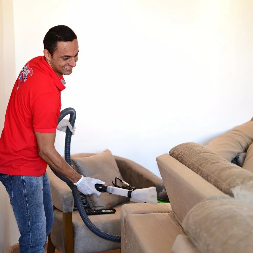 Profissional da Magic Clean higienizando um sofá